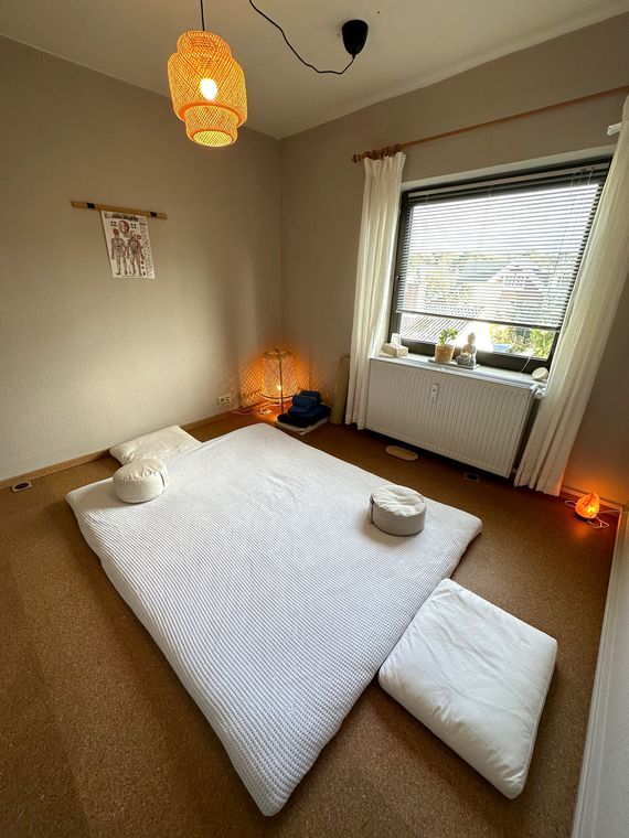 Behandlungsfuton am Boden mit Tüchern und Kerzenlicht